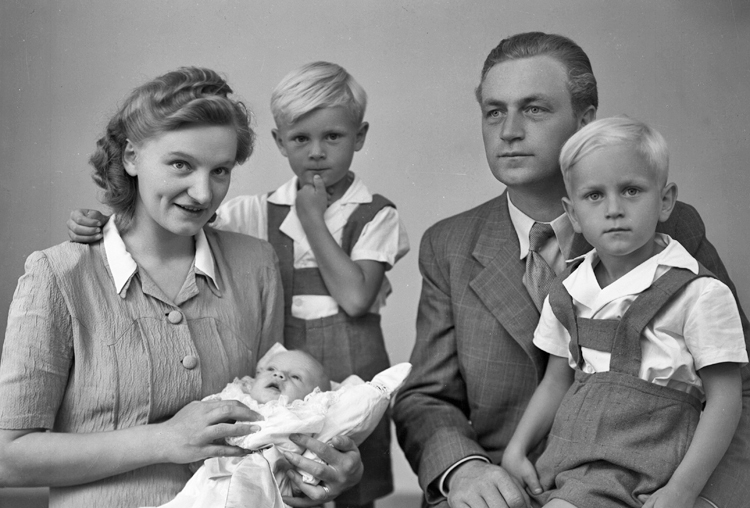 Foto av en familj med tre små pojkar (en baby).
Ateljéfoto.