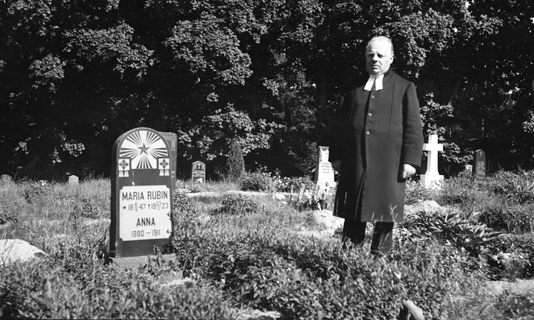 Foto på en gravsten med kyrkoherde Sven Rubin (1883-   ), Karlstorp, stående bredvid.