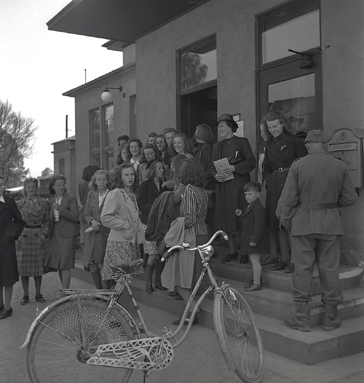 Betplockarna, 1942. 
Ett antal tonårsflickor har samlats på trappan utanför
järnvägsstationen i Växjö, innan avfärd.