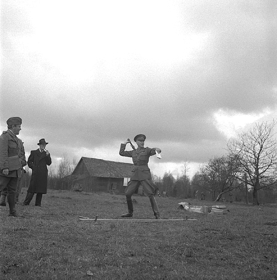 Hemvärnets fälttävlan, 22/4 1945.
Översten vid I 11 (?) provar kast med handgranatsattrapp. I bakgrunden syns en lada.