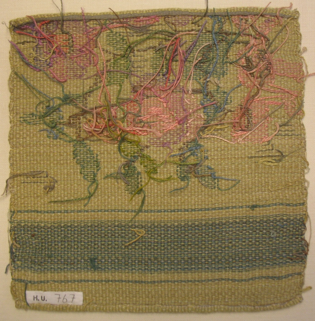 Tidigare katalogisering enl uppgift av Elisabeth Thorman kompletterad 1958 av Elisabeth Stawenow:

Möbelklädsel, prov, 24 x 23 cm. H.V.-teknik. Varp av vitt bomullsgarn. Väft av lingarn. Botten melerad i ljusgult och ljusgrönt. Grön rand och inplockat mönster en rosenbukett i rosa, grönt och brunt.
Thyra Grafströms ateljé, Nr 142 b.