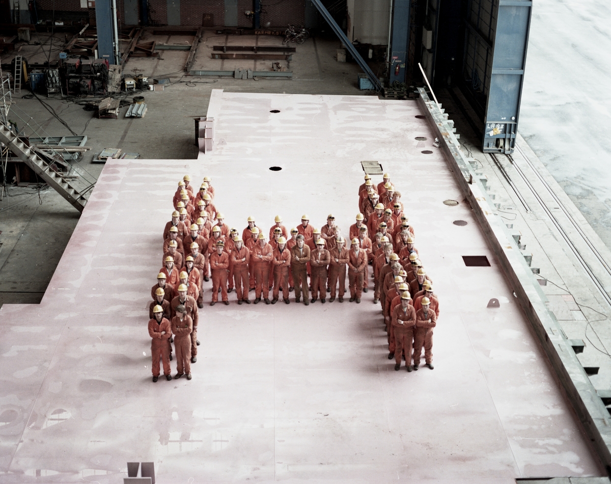 HMV. Arbeidere som stiller opp i en "H" på gulvet i Nordsjøhallen for å bli fotografert.