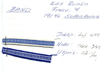 Två bandprover, vävda bomullsband fästade på en kartong daterad 1979. Banden är 10 mm breda, ett i vitt och blått, ett i blått och vitt. Kartongen är märkt med texten: "BAND Edtit Romlin Freav. 4 191 46 Sollentuna" samt "Inköp: Lxf 6/79 Netto: Mds 6/79 Utpris: 12:-/m".