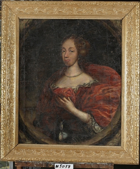 Oljemålning på duk. 
Porträtt föreställande kvinna iklädd röd klänning, pärlband i
håret, pärlhalsband runt halsen samt pärlarmband runt höger arm.
Brun bakgrund inom delvis synlig oval av lager.