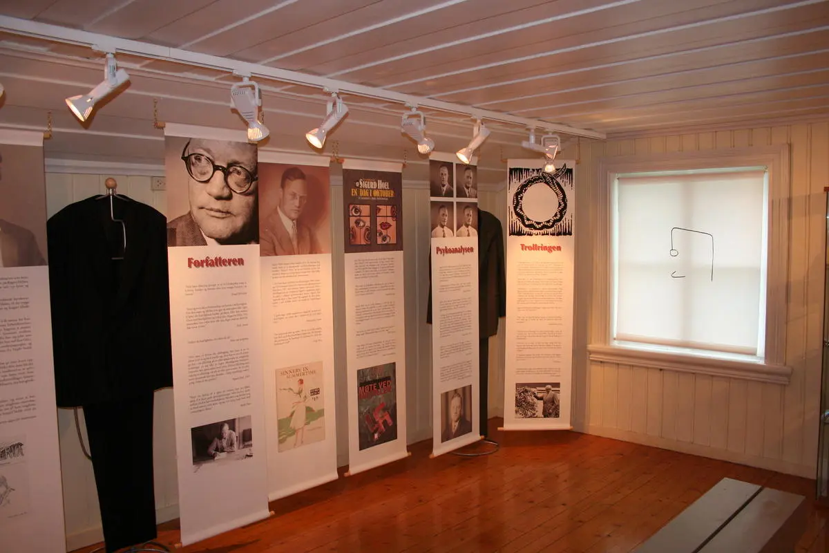 Oversiktsbildet over utstillingen om Sigurd Hoel på Sagstua skolemuseum - Sigurd Hoels barndomshjem. Seks tekstplansjer og en dress.