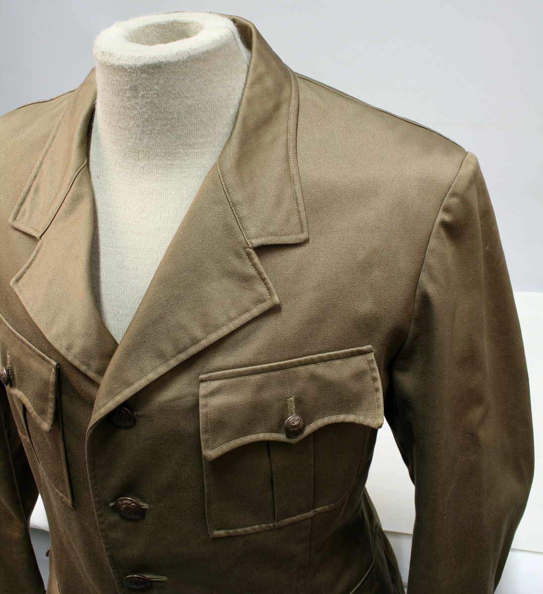 Nokså lik 1953 modellen. Enkeltkneppet brun jakke med fire knapper, fire ytterlommer og nedbrettet krage.