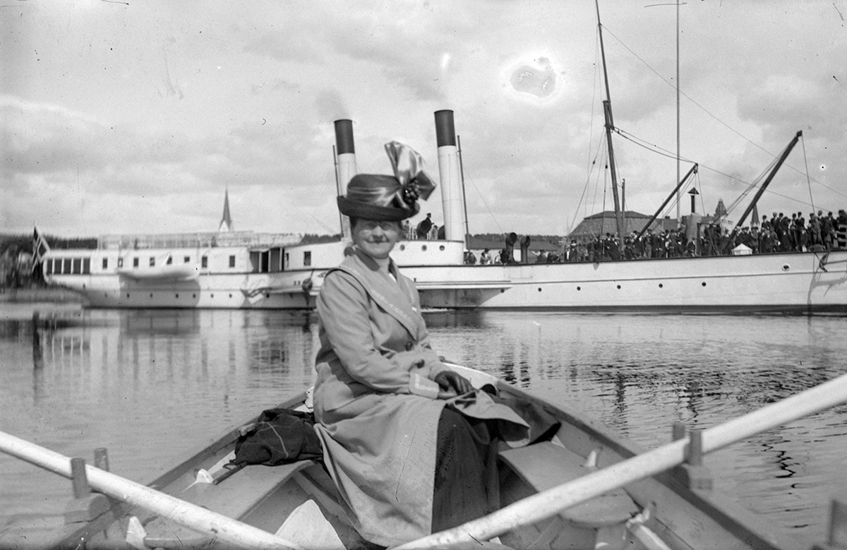 Hamar, Lovise Johannessen (1859-1932) i en robåt, kvinnedrakt, hatt, mjøsbåten D/S Kong Oscar, (gift med bakermester O. Johannessen)