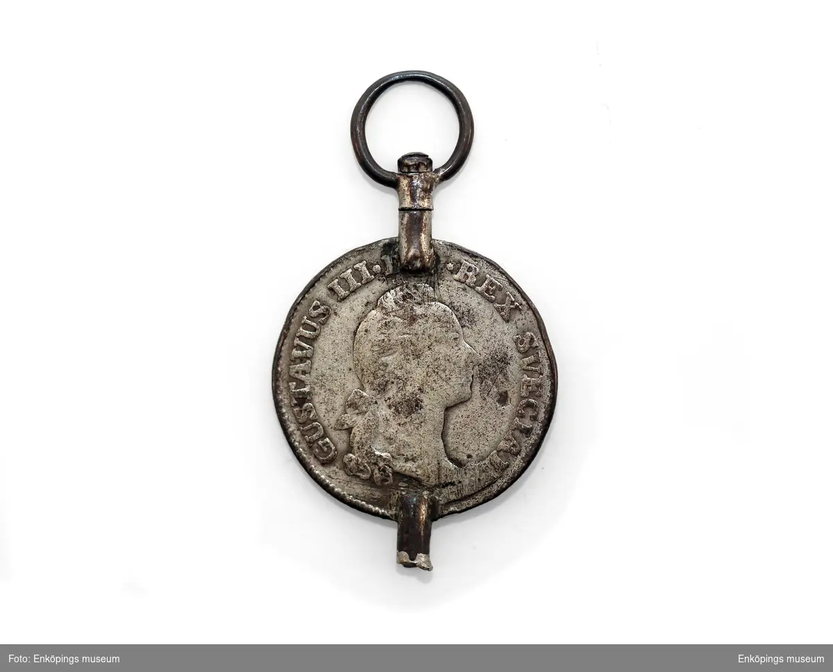 Urnyckel gjord av ett 1/6 Riksdaler mynt från 1778. Gustavus III. REX SVECIAE på framsidan.