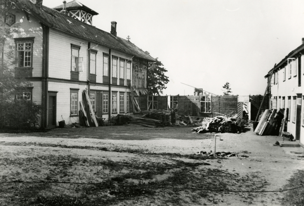 Bilde av tunet på Ringve gård mot vest. Bildet viser nedrivingen av mellombygningen.
Deler av bygningens 1. etasje gjenstår.