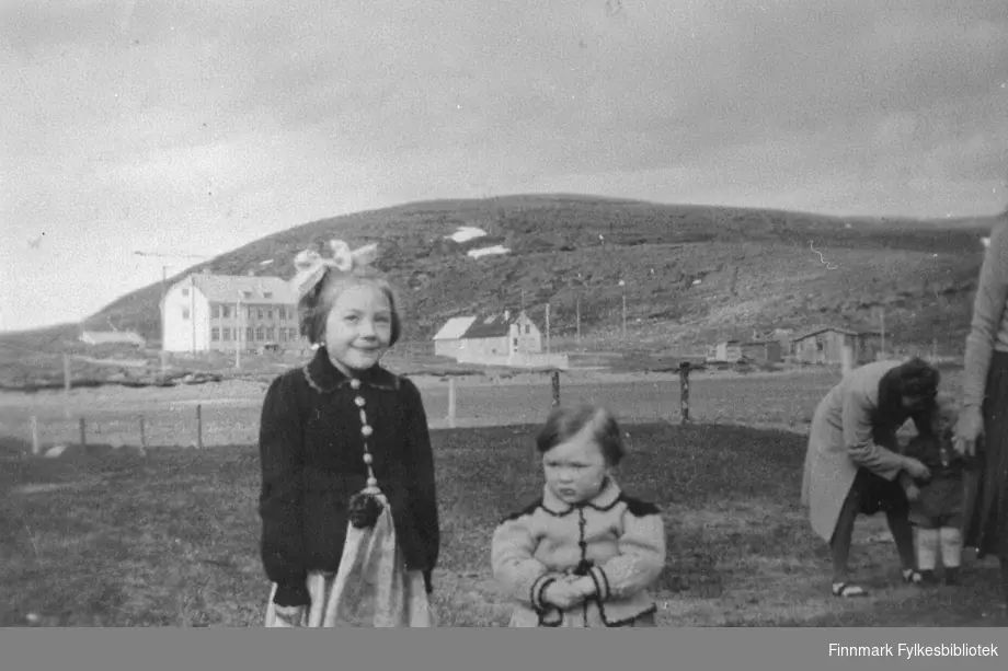 Bildet tatt i Kiberg, antakelig i tidsrommet 1948. Bildet er tatt mot Internatet. I forgrunnen Rønnaug Abrahamsen, Ingebjørg Abrahamsen.