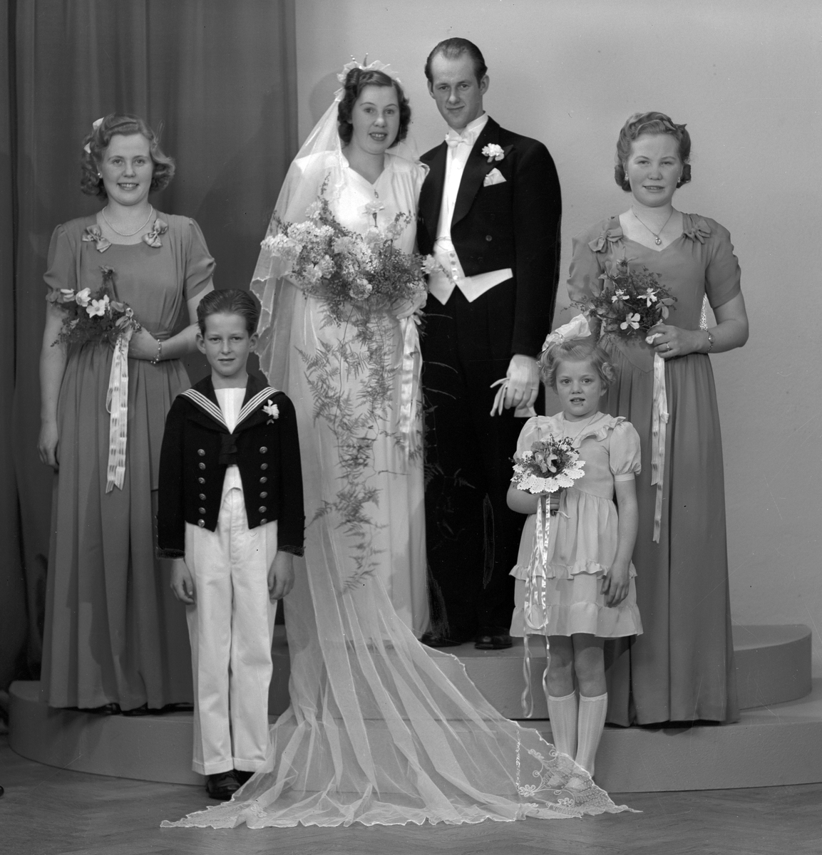 Brudpar Göte Erlandsson med brudnäbbar och brudtärnor. Herr Göte Erlandsson, Södra Fältskärsgatan 27 A, Gävle. 23 februari 1946.