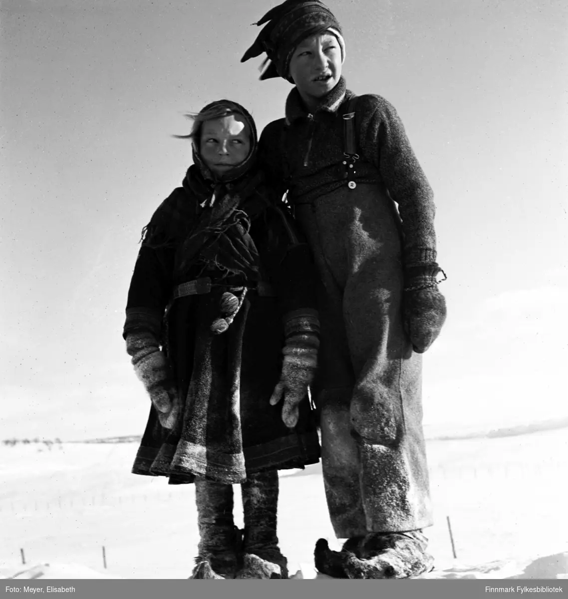 Sigrid Madsen og Odd Madsen fotografert ved påsketider 1940. Sigrid i samisk kofte og Odd med samisk lue.