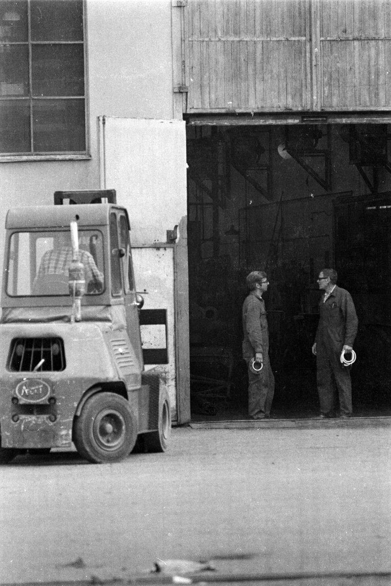 Ekensbergs varv. Varvsarbetare och truck vid ingången till maskinverkstaden.