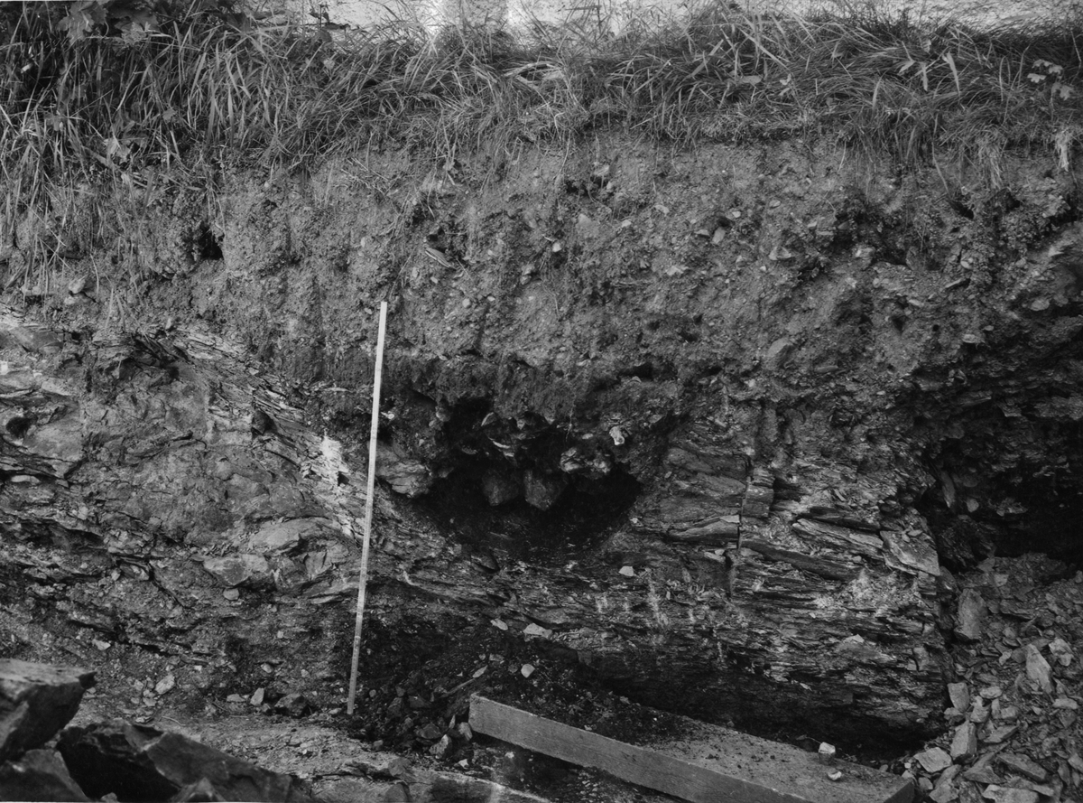 Rester etter "forhistorisk grav" funnet vest for mellombygningen i forbindelse med gravearbeider i august 1946. Fordypning i berggrunnen ca. 50 cm ned i terrenget.