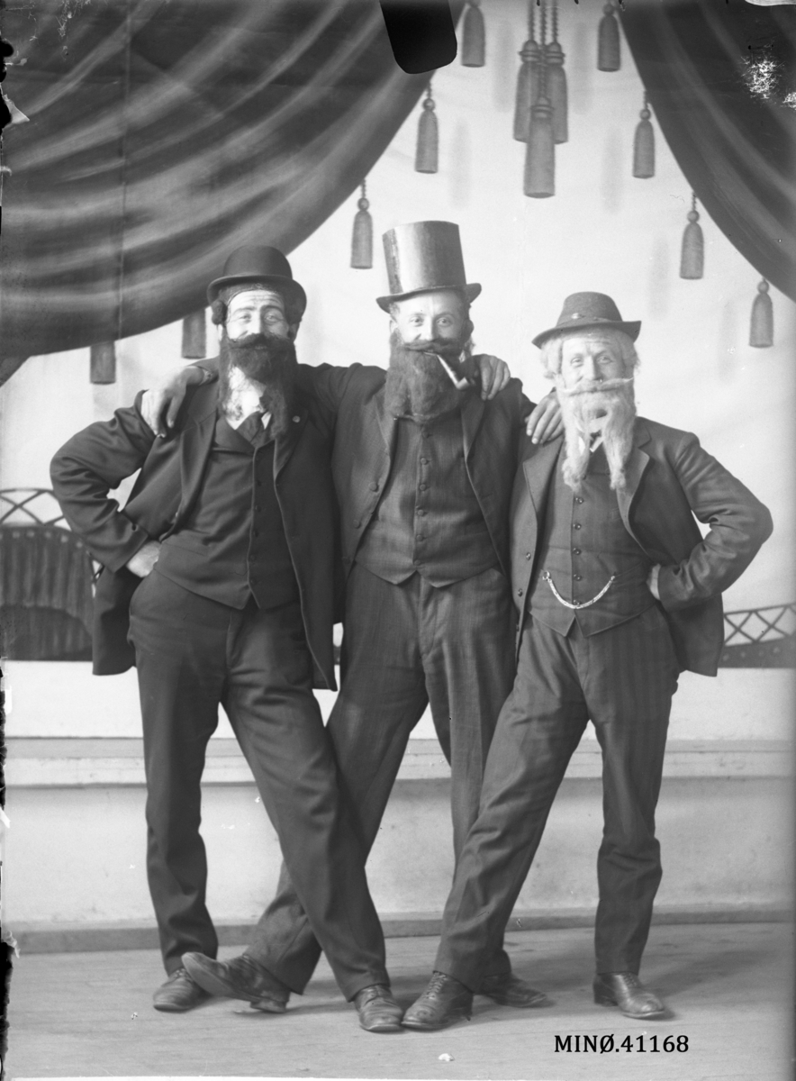 Portrett av tre menn utkledd med skjegg. Holberg, Haugen og Heggbom.