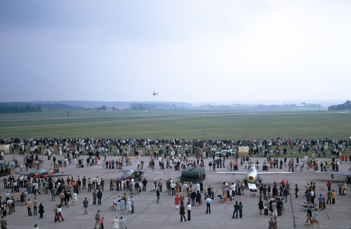 Flygdagen på Malmen den 10 september 1972. Publik och utställning på flygfältet. Ett propellerflygplan under flyguppvisning.