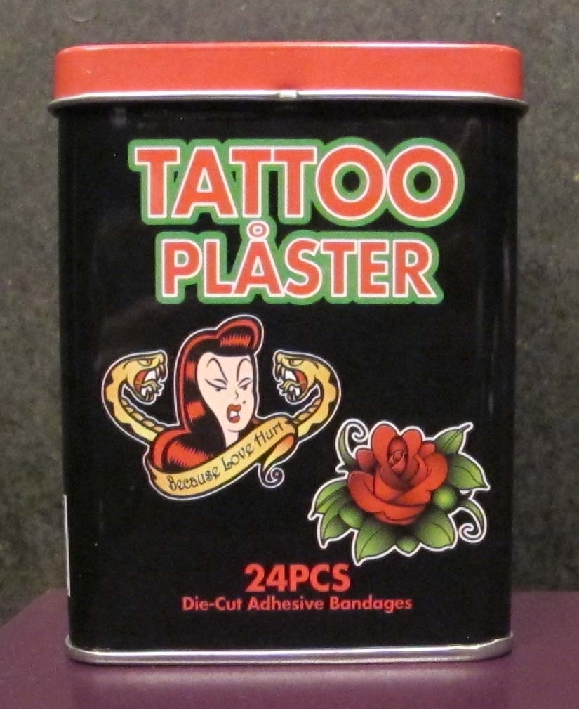 Plåsterburk innehållande plåster med tatueringsmotiv.