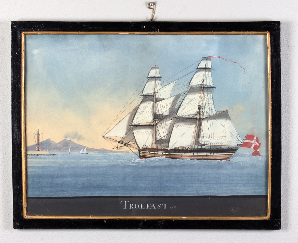 Briggen TROEFAST med full seilføring, ved innseiling til Napolibukta med Vesuvs i bakgrunnen. Skipet fører dansk flagg med kongelig monogram i akter, og vimpel i masten.