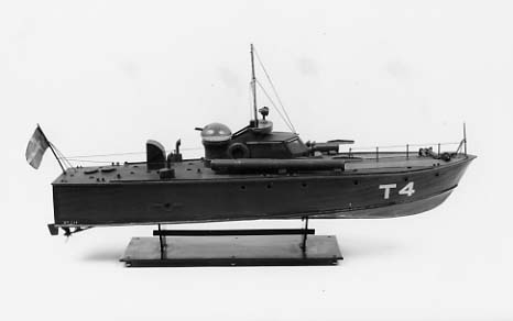 Fartygsmodell av torpedbåten T4. Två däckstuber, dubbel kulspruta i kupollavettage. Har handelsflagg.