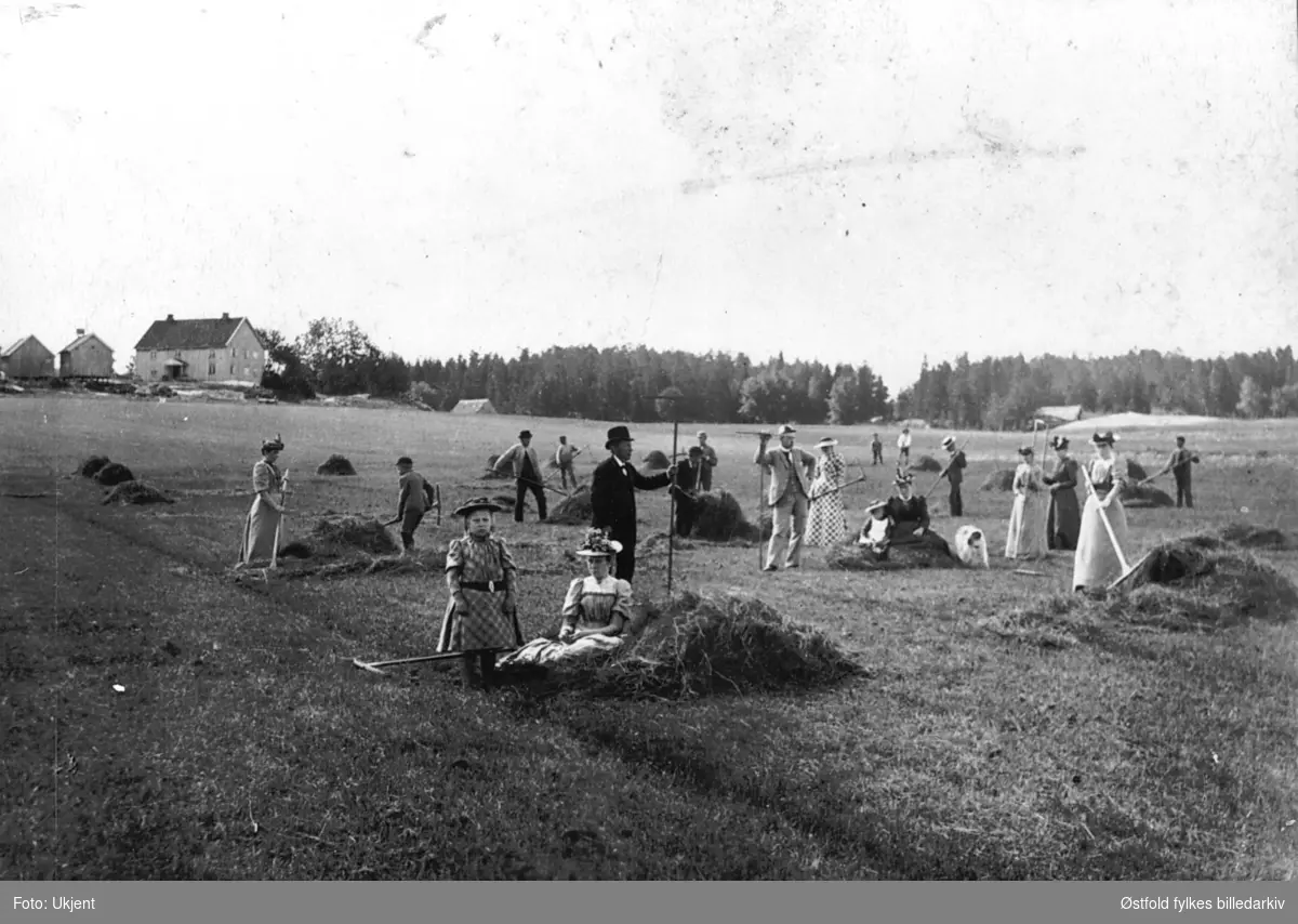 Arbeid på jordene, høyonn, i bakgrunnen gården Vestre Bråte i Hobøl, ca. 1880.