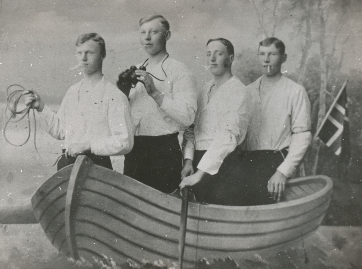 Gruppeportrett av 4 unge menn i en kunstig båt i et fotostudio.