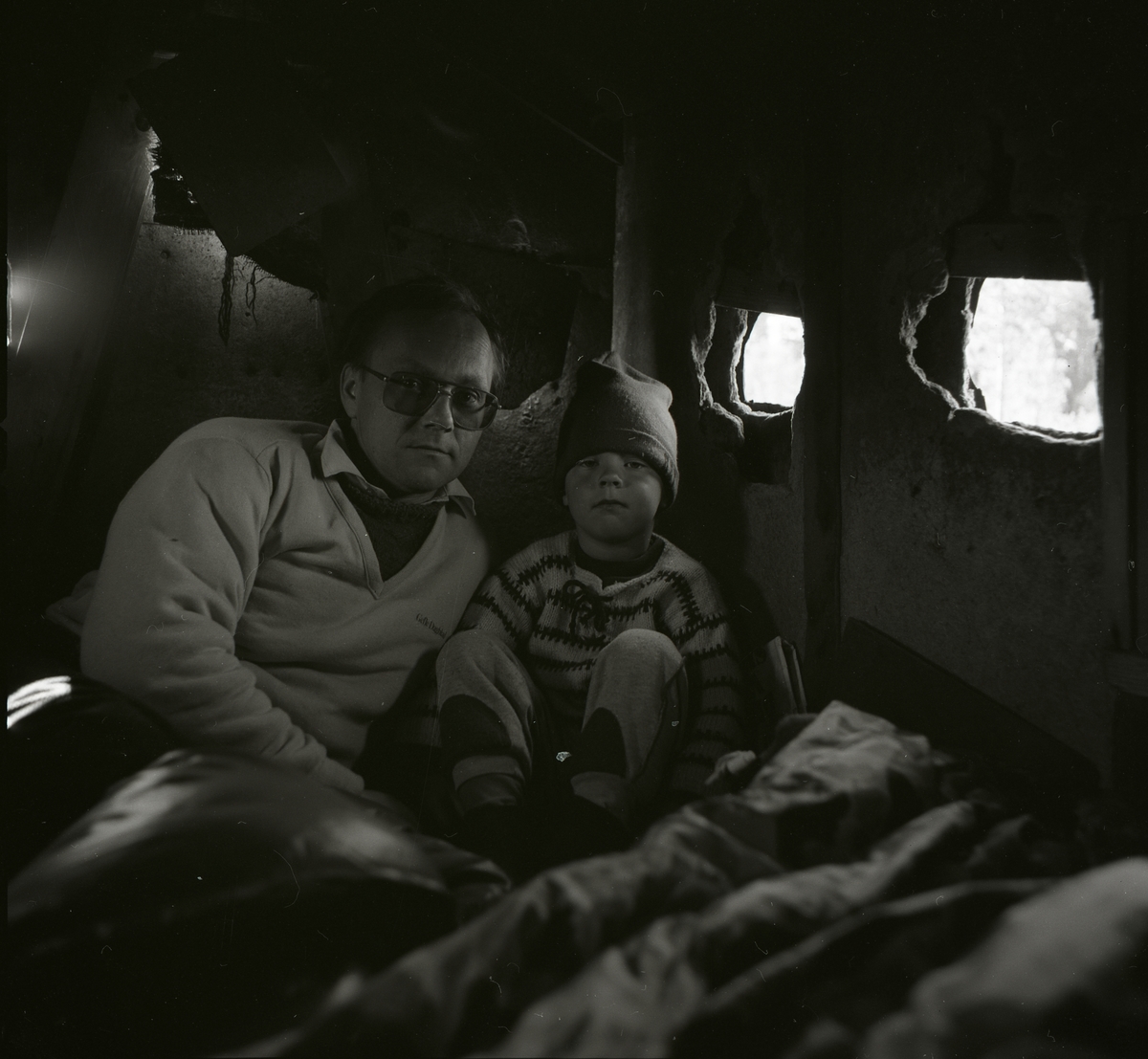 En man och en liten pojke i en koja på Degelmyren.