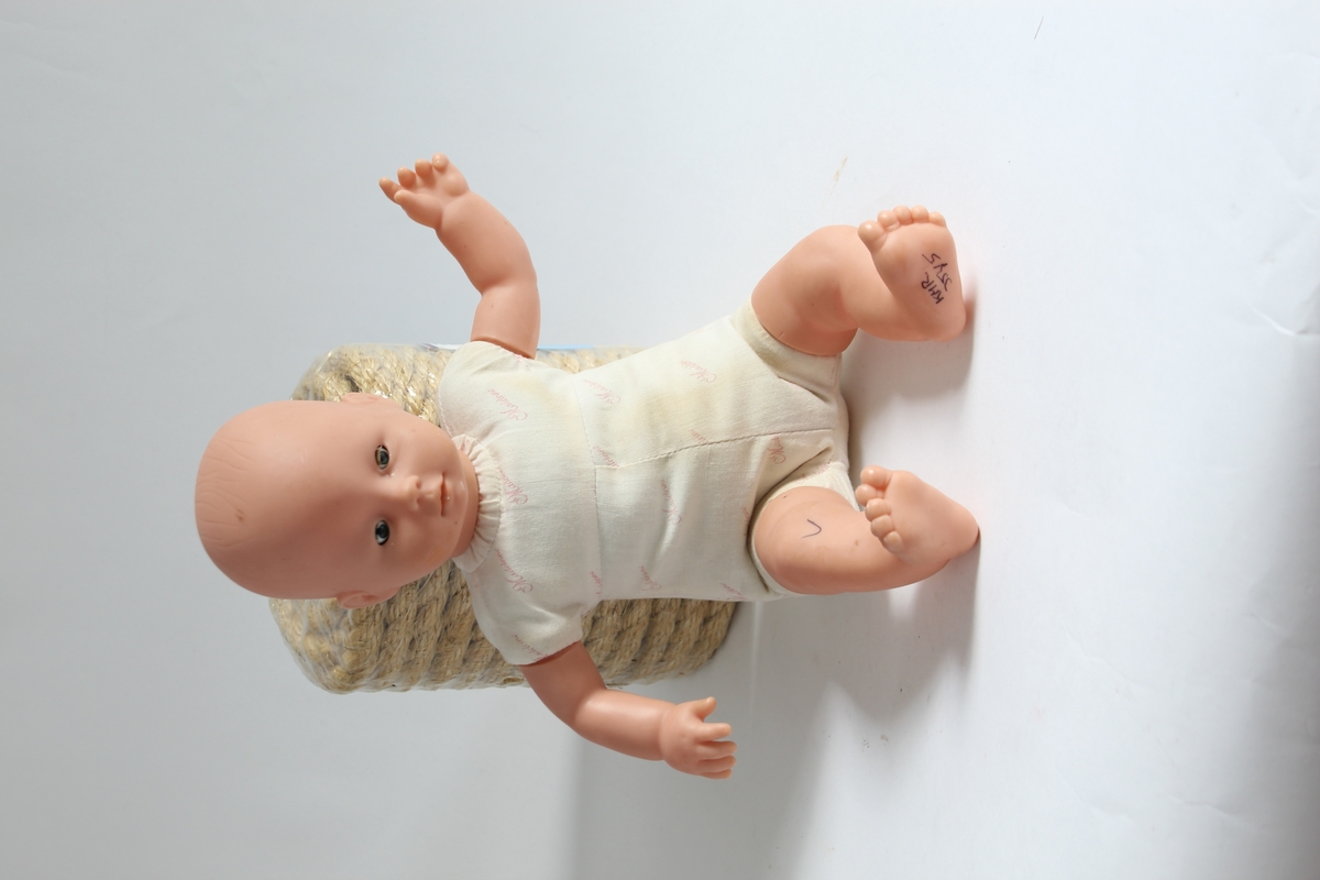 Tilhørt jente (f. 2001) i Sør-Odal. 

En babydukke. Hodet, beina og armene er av plast. Kroppen er av stoff. Ingen klær som hører til.