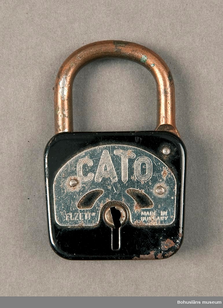 Nyckel saknas. Låset är svart med rostfri bricka. Märkt: "Cato. Elzett. Made in Hungari".
