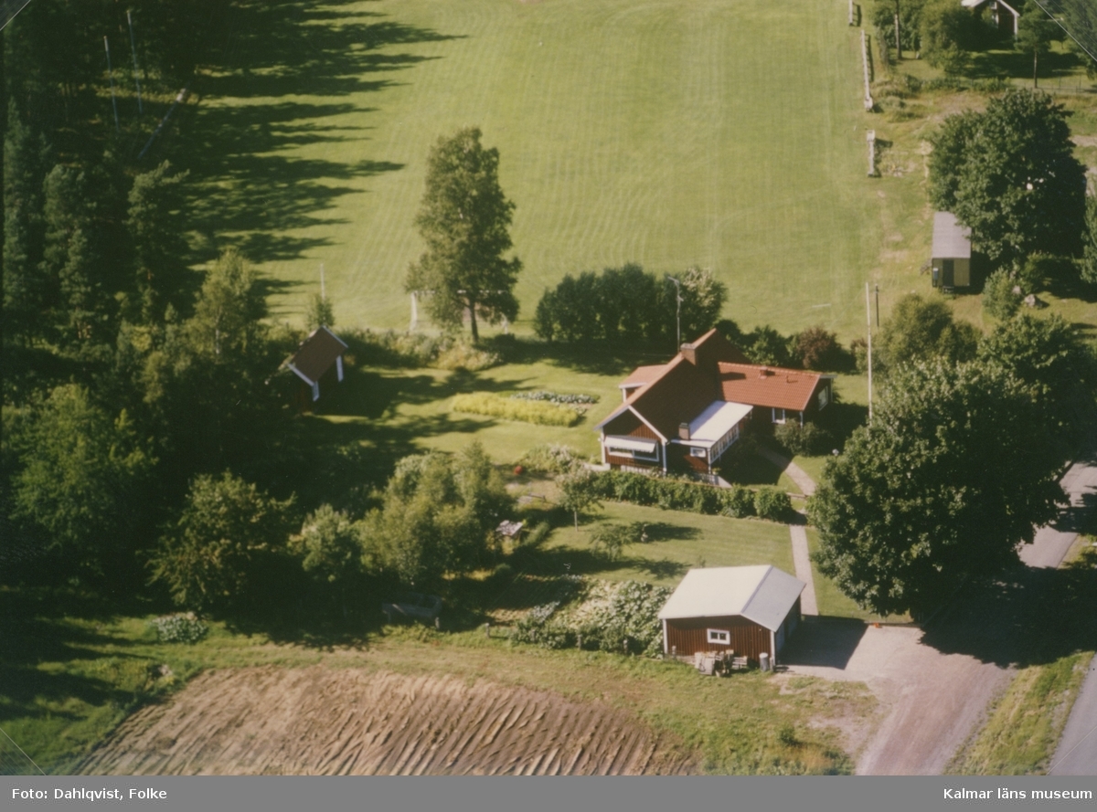 Ett bostadshus med trädgård vid åkermarker i Sankt Sigfrids socken.