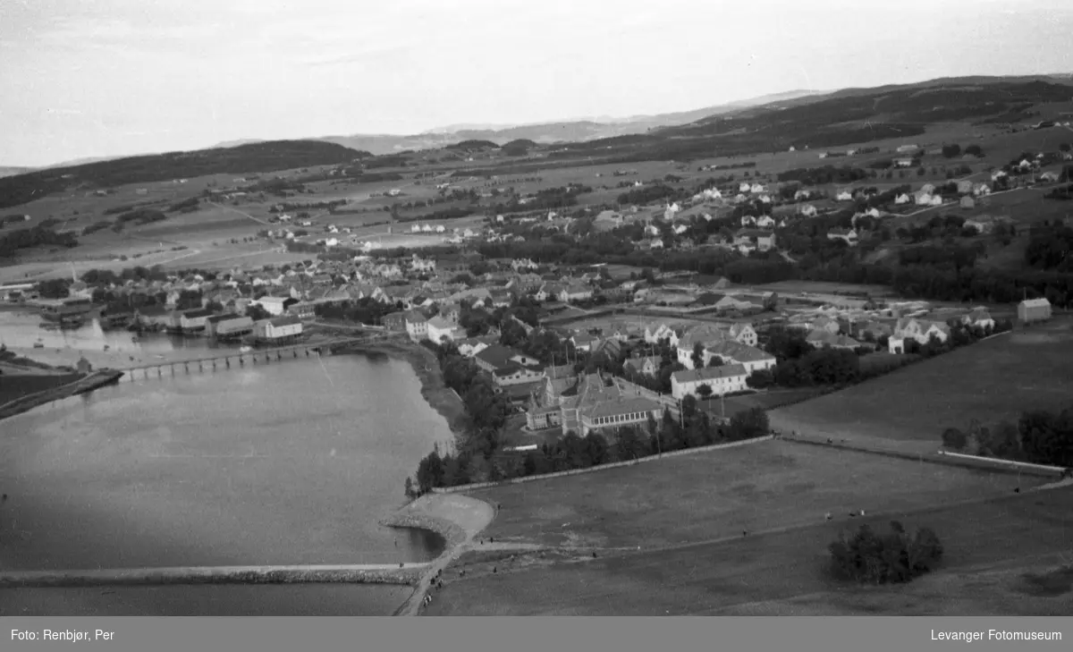 Flyfoto av Levanger, tatt av tenåringen Per Renbjør med sin fars Leica.  Oversikt over byen med Sundbrua og jetèen.