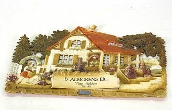 Reklamalmanacka från affär i Viste-Askjum. (B. Almgrens eftr.)
Almanacksbilden är i relief och föreställer en villa med trädgård där en flicka går och vattnar. Färglagd och försedd med glitter.