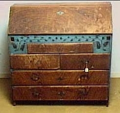 Brunådrad snedklaffbyrå. Klaffen är utvändigt blåmålad med svart växtranka. 6 blåmålade, numrerade lådor samt "JJS 1851" innanför klaffen. Inköpspris 6 kr.