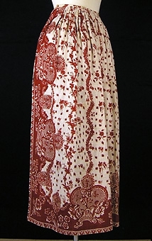 Enl liggare: "Förkläde af hvitt linnetyg med tryckta röda rosor"

Oblekt botten med tryckt mönster i olika röda nyanser. Rynkad upptill. Knytband av vit bomull

Trycket är kopierat av Ljungbergs i Floda 1982