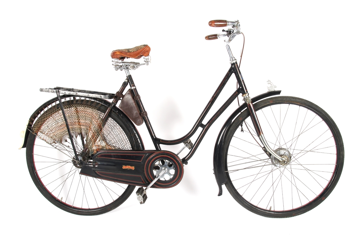 Svartlakkert damesykkel med taske til verktøy under setet og kjolenett på bakhjul. Sykkelen har Torpedo frinav.
