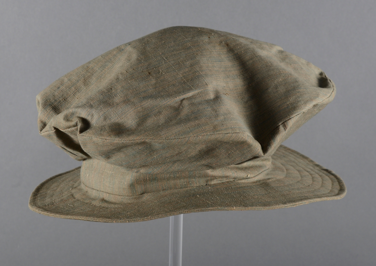 Hatt av vindjakkestoff med bred brem og bred, flat pull. En slik hatt ble gjerne brukt av jenter på 10-12 år på begynnelsen av 1900-tallet.