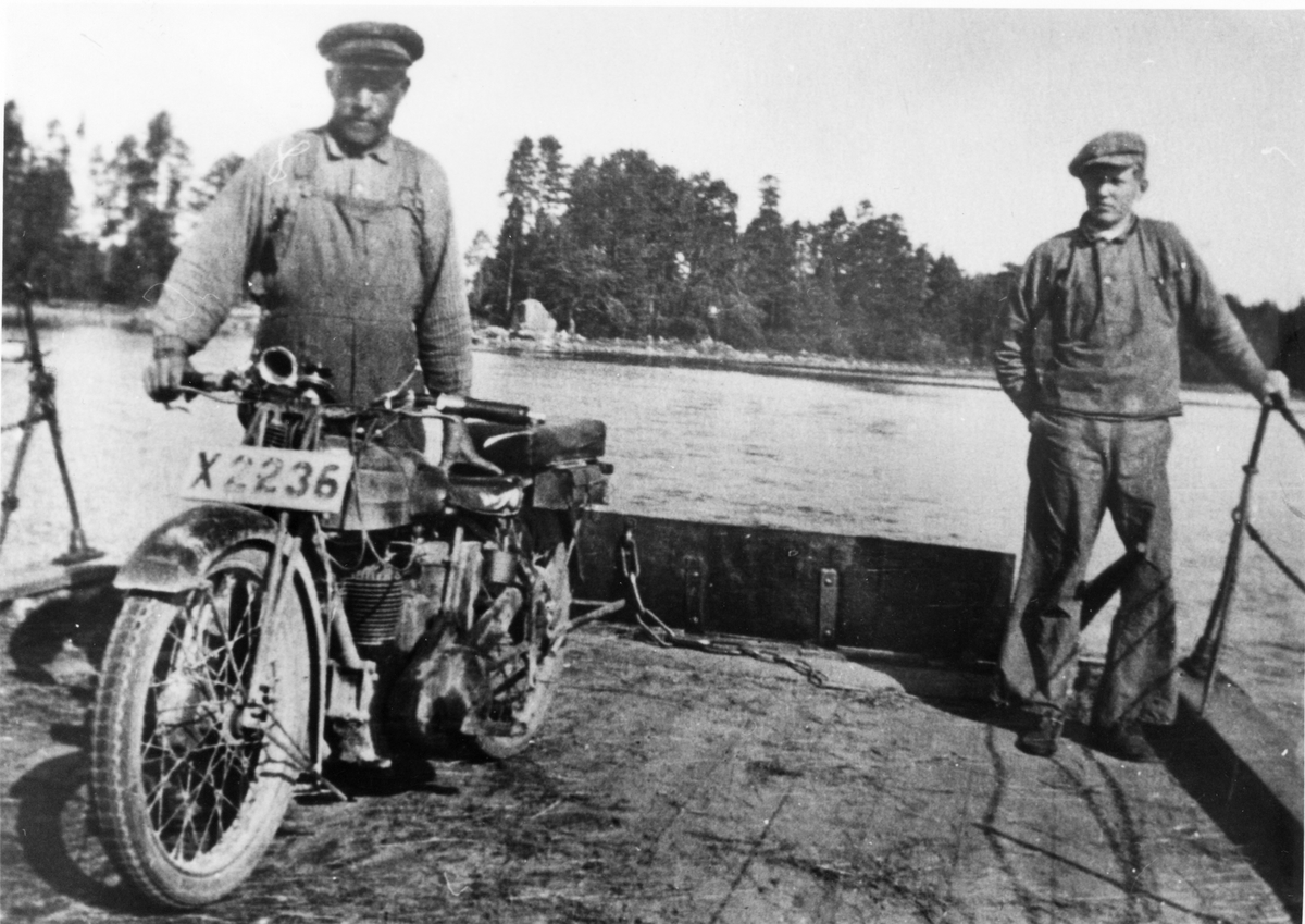 Södra Färjsundet.
Färjkarlen Per Olof Pettersson med son. Fotot taget på 1920-talet, färjan roddes då med åror. Motorcykeln tillhörde skolkökslärarinnan Astrid Brundin (dotter till kyrkoherden). Det var även då ovanligt med kvinnliga motorcykelförare.