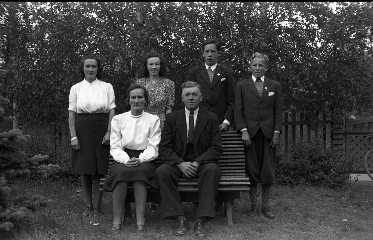 Familieportrett av Marit og Gustav Adolf Petterson som sitter foran, og sønner og døtre som står bak. Med bilde nr. en som referanse: Lengst til venstre står dattera Borghild Serine, guttenes fornavn er hhv. Gustav Adolf og Oddvar, men det er uklart hvem er hvem, mens fornavnet til dattera i hvit bluse er ukjent.