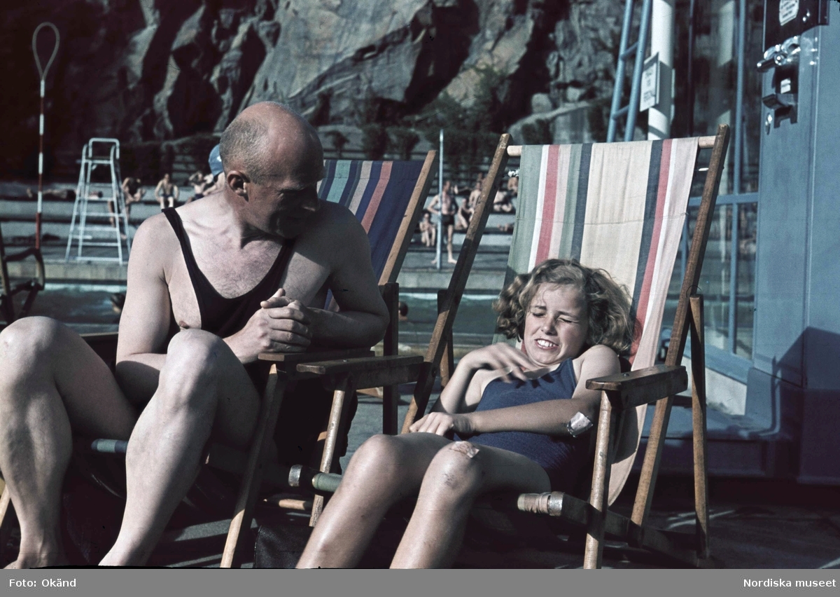 Bassängbad. Vanadisbadet, Stockholm. Fotografen Gunnar Lundh och hans dotter Jytte sitter i varsin solstol iklädda baddräkter.
