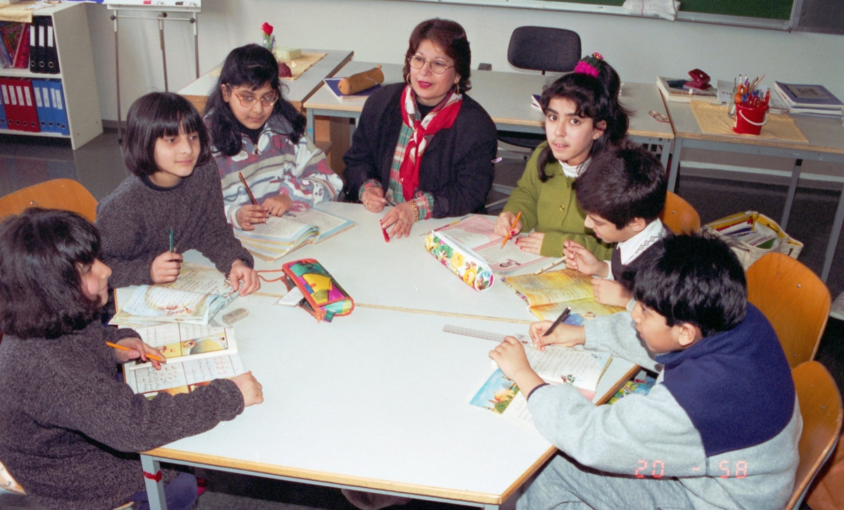 Morsmål-undervisning på urdu.
Gruppebilde av fire jenter, to gutter og en lærer.
