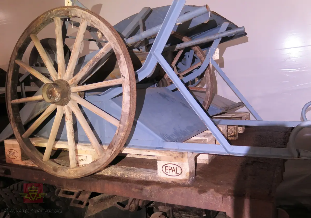 Vogn/kjerre av metall med jernbeslåtte trehjul. Behandlet med gråblå rusthindrene maling.