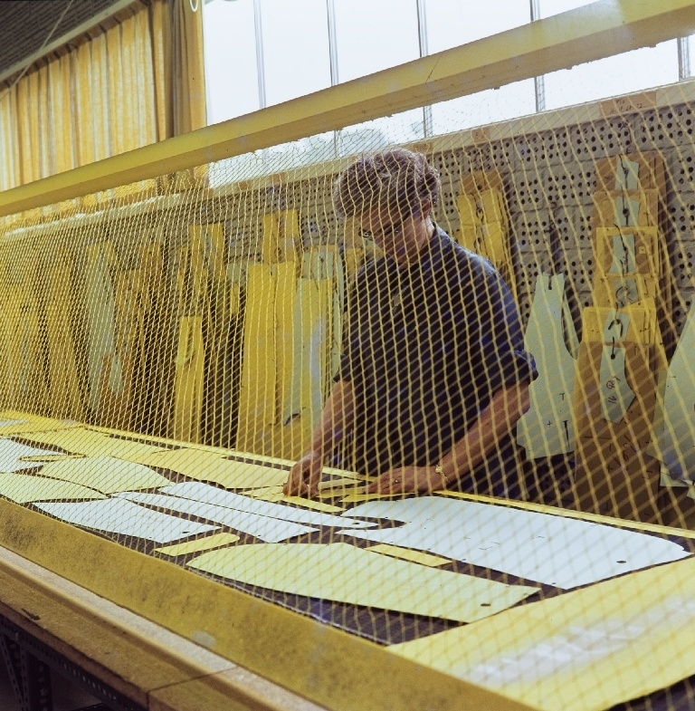 Ansatt i konfeksjonsfabrikken hos Jonas Øgænd Sandnes lager en skjæretegning med en fargemaskin.