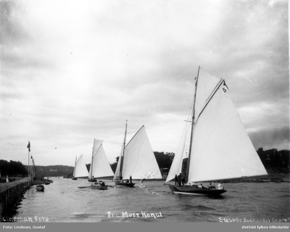 Parti fra Moss Kanal - mange seil- og robåter, regatta, lystbåt seilas. . Ukjent når, ant. etter  1902. Til venstre Jeløy og bysiden på høyre side. I bakgrunnen Rosnæs på Jeløy.
