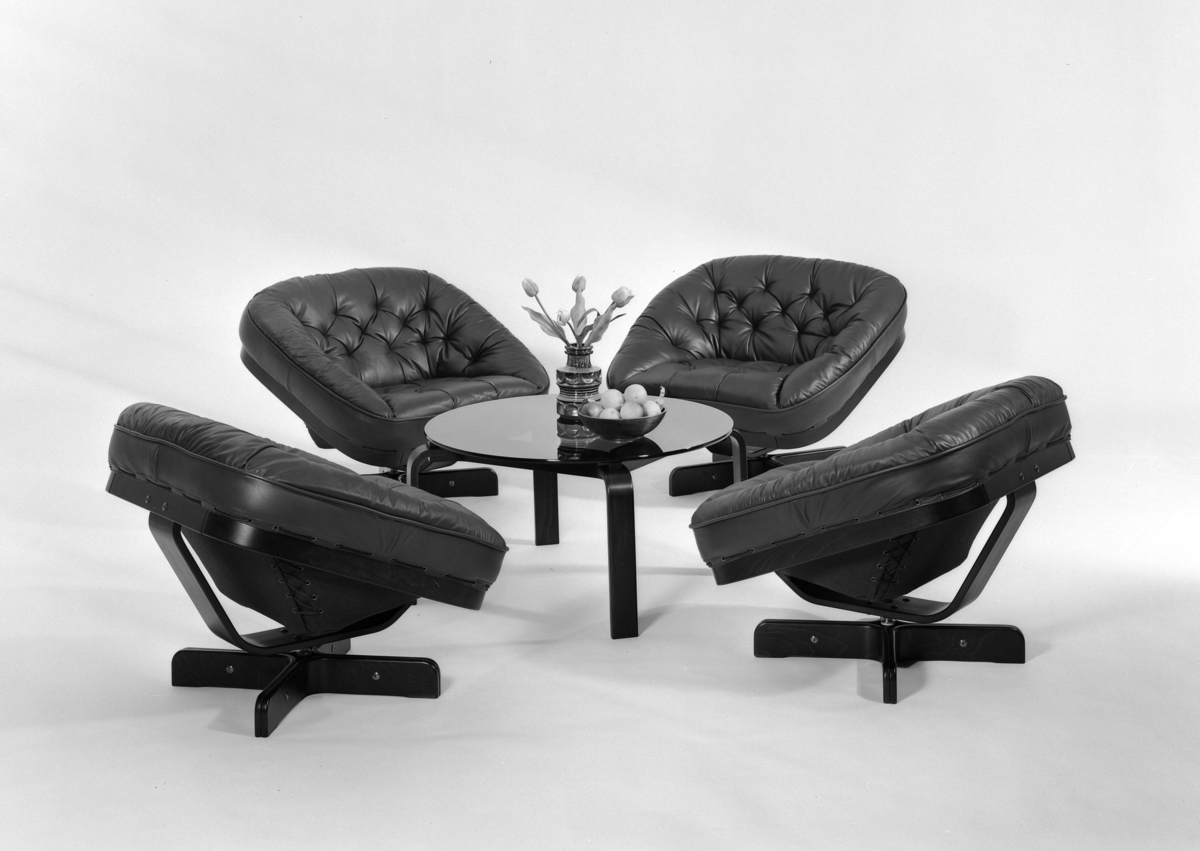 Sittegruppe. Fire stolar (svingstolar) satt i gruppe rundt glassbord.