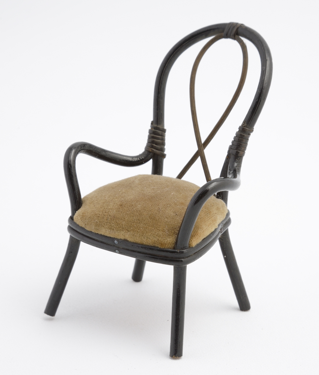 Miniatyr av karmstol i svart rotting med sittdyna i grålila sammet.