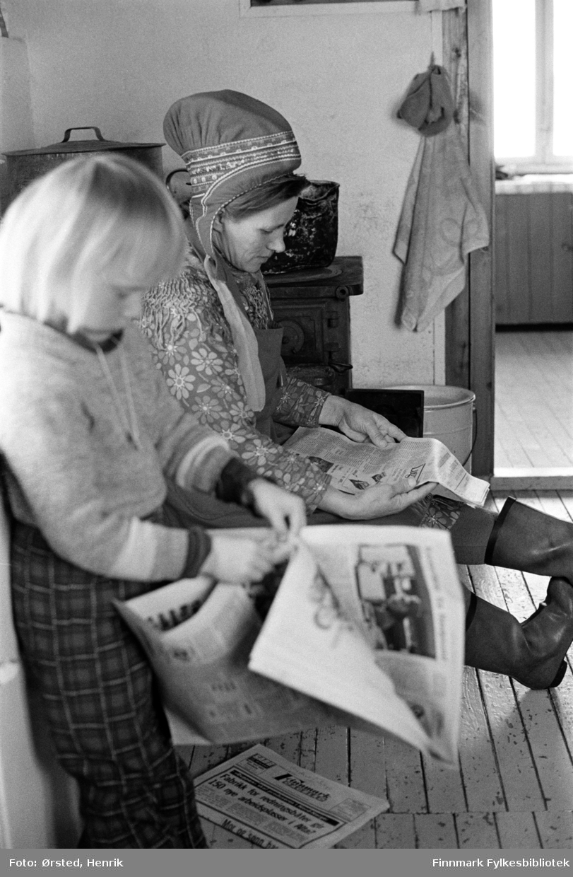 Anne Marie Isaksen Buljo og datteren Ragnhild Buljo, på kjøkkenet ved vinterbeiteplassen Bavdajohka.  I bakgrunnen ser vi en som leser avisen. Familien er fortsatt i Bávttajohka om vinteren. 

Fotograf Henrik Ørsteds bilder er tatt langs den 30 mil lange postruta som strakk seg fra Mieronjavre poståpneri til Náhpolsáiva, videre til Bavtajohka, innover til øvre Anárjohka nasjonalpark som grenser til Finland – og ruta dekket nærmere 30 reindriftsenheter. Ørsted fulgte «Post-Mathis», Mathis Mathisen Buljo som dekket et imponerende område med omtrent 30.000 dyr og reingjetere som stadig var ute i terrenget og i forflytning. Dette var landets lengste postrute og postlevering under krevende vær- og føreforhold var beregnet til 2 dager. Bildene gir et unikt innblikk i samisk reindriftskultur på 1970-tallet. Fotograf Henrik Ørsted har donert ca. 1800 negativer og lysbilder til Finnmark Fylkesbibliotek i 2010.