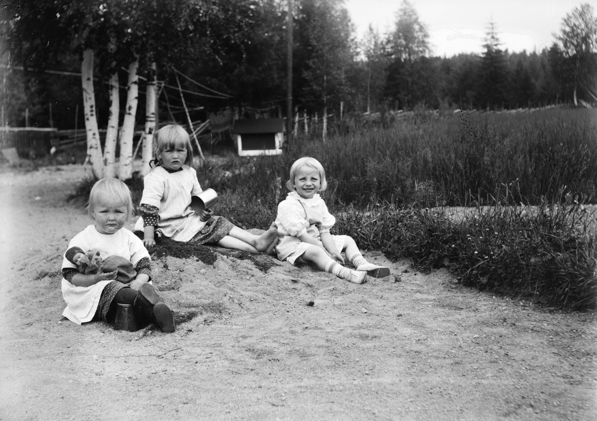 Marit Liljefors med två andra små flickor leker i sanden, sannolikt i Sverige