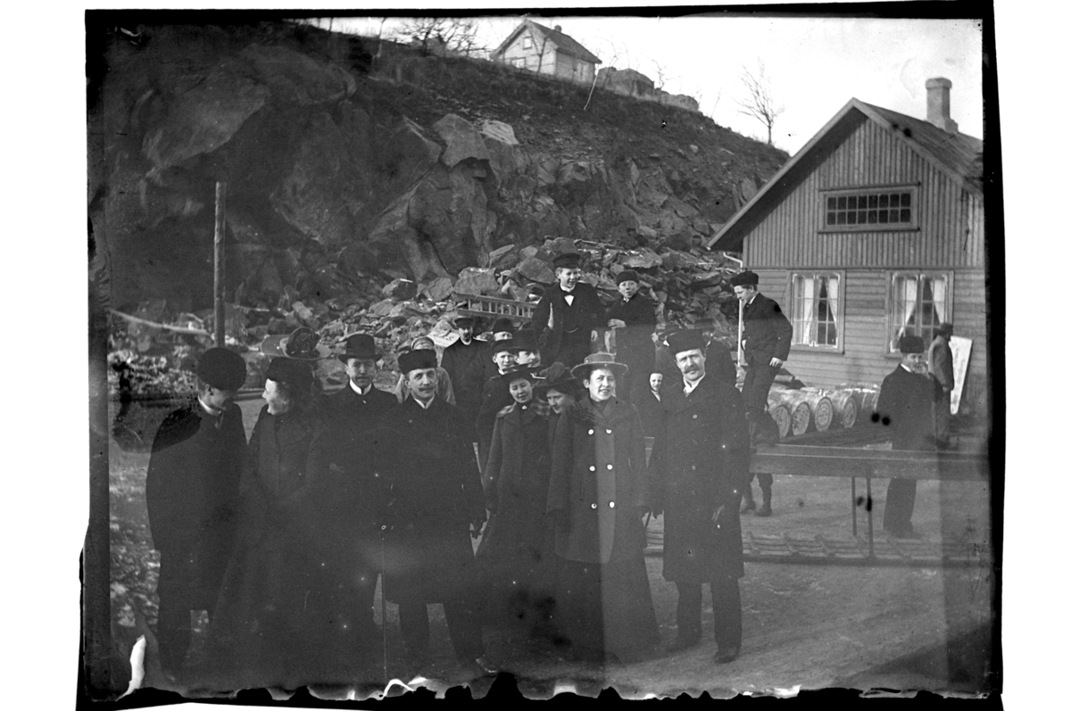 En rekke kvinner og menn inspiserer byggingen av Pengeveien ved Verven i Farsund. Fotografert 1903.