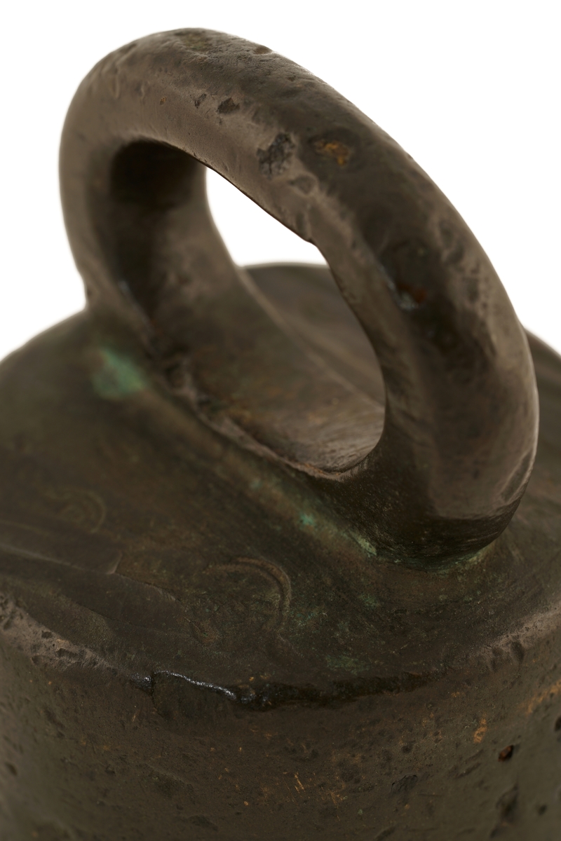 Lodd av bronse eller messing med ovalt håndtak. På oversiden forsynt med flere
utydelige stempler.