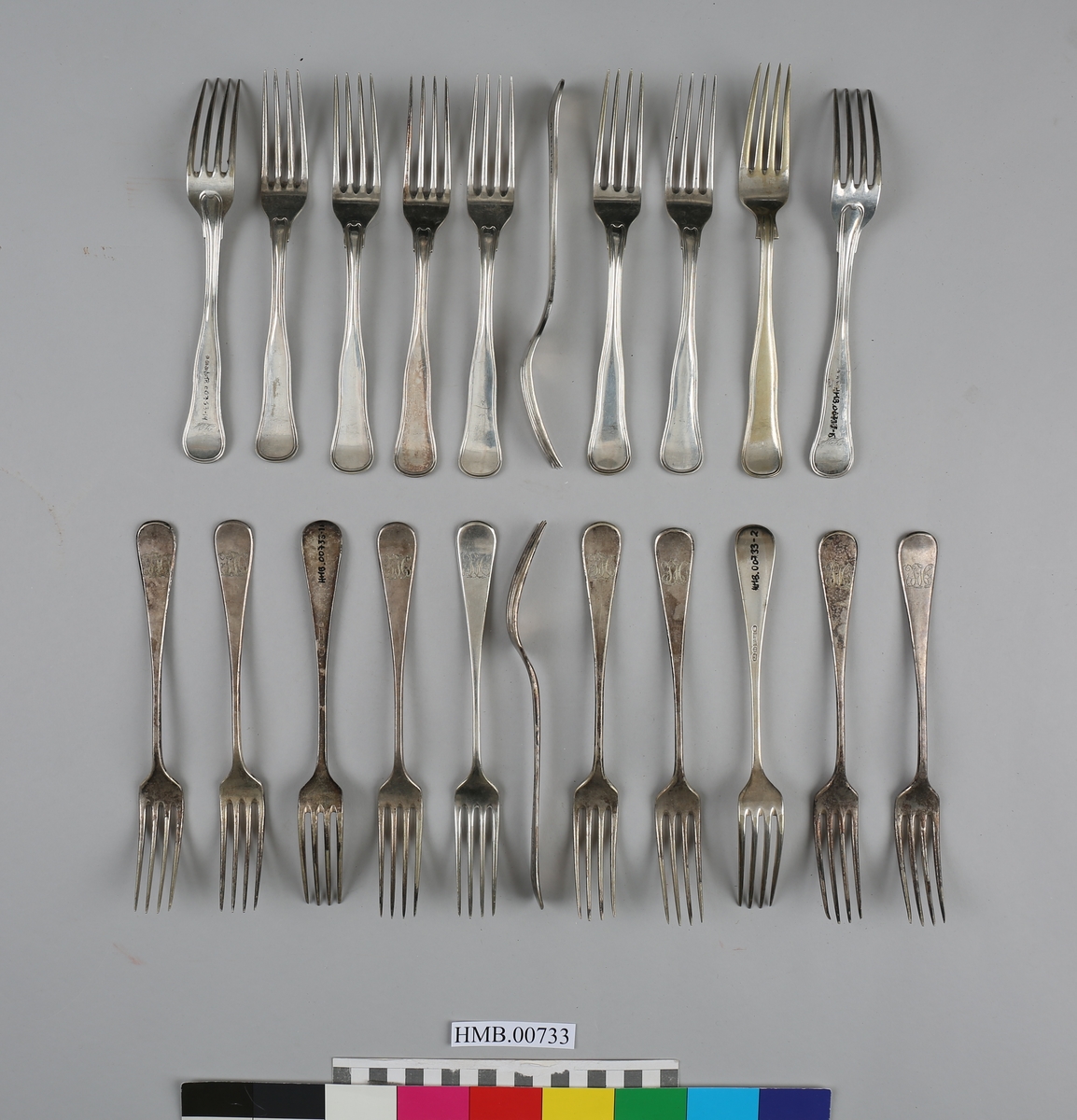 21 gafler i sølvplett, hvorav 20 med Harmens-familiens monogram.