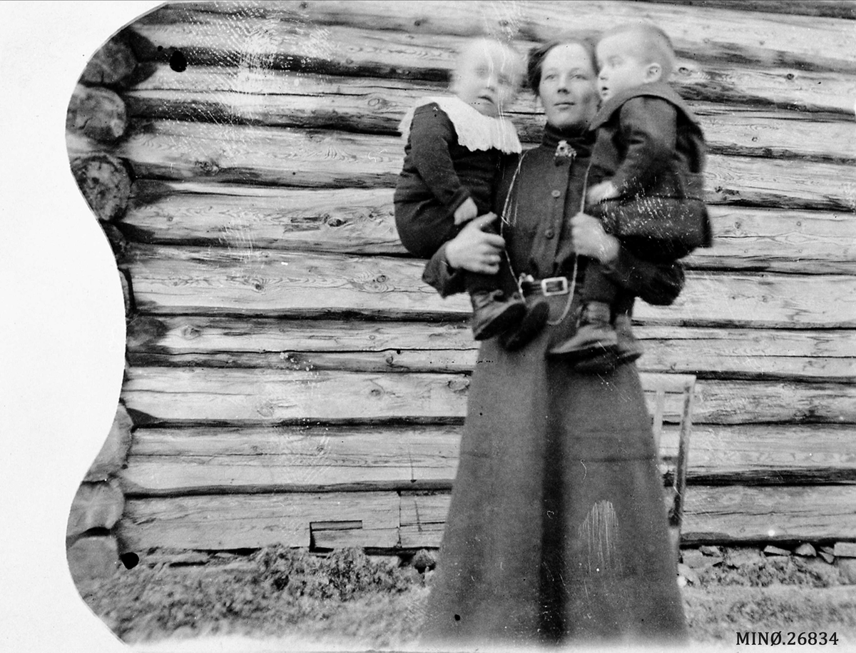 Portrett av mor med to barn på armen